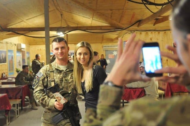 A Soldier with the 4th Stryker Brigade Combat Team, 2nd Infantry Division, poses with comedian Iliza Shlesinger during a USO tour, Dec. 16, 2012, at Forward Operating Base Masum Ghar, Afghanistan.