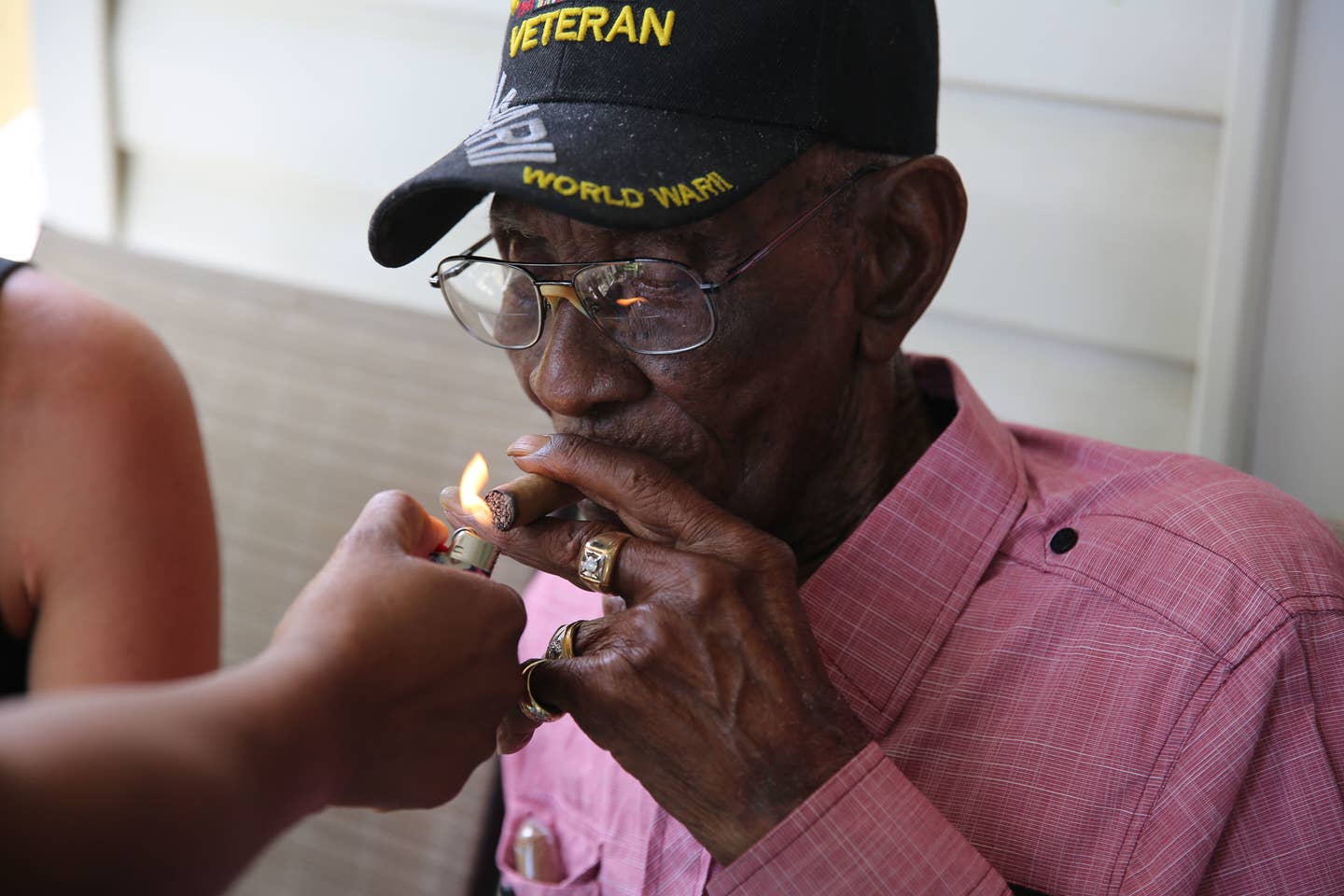 Richard Overton getting a light for his cigar on his 112th birthday.