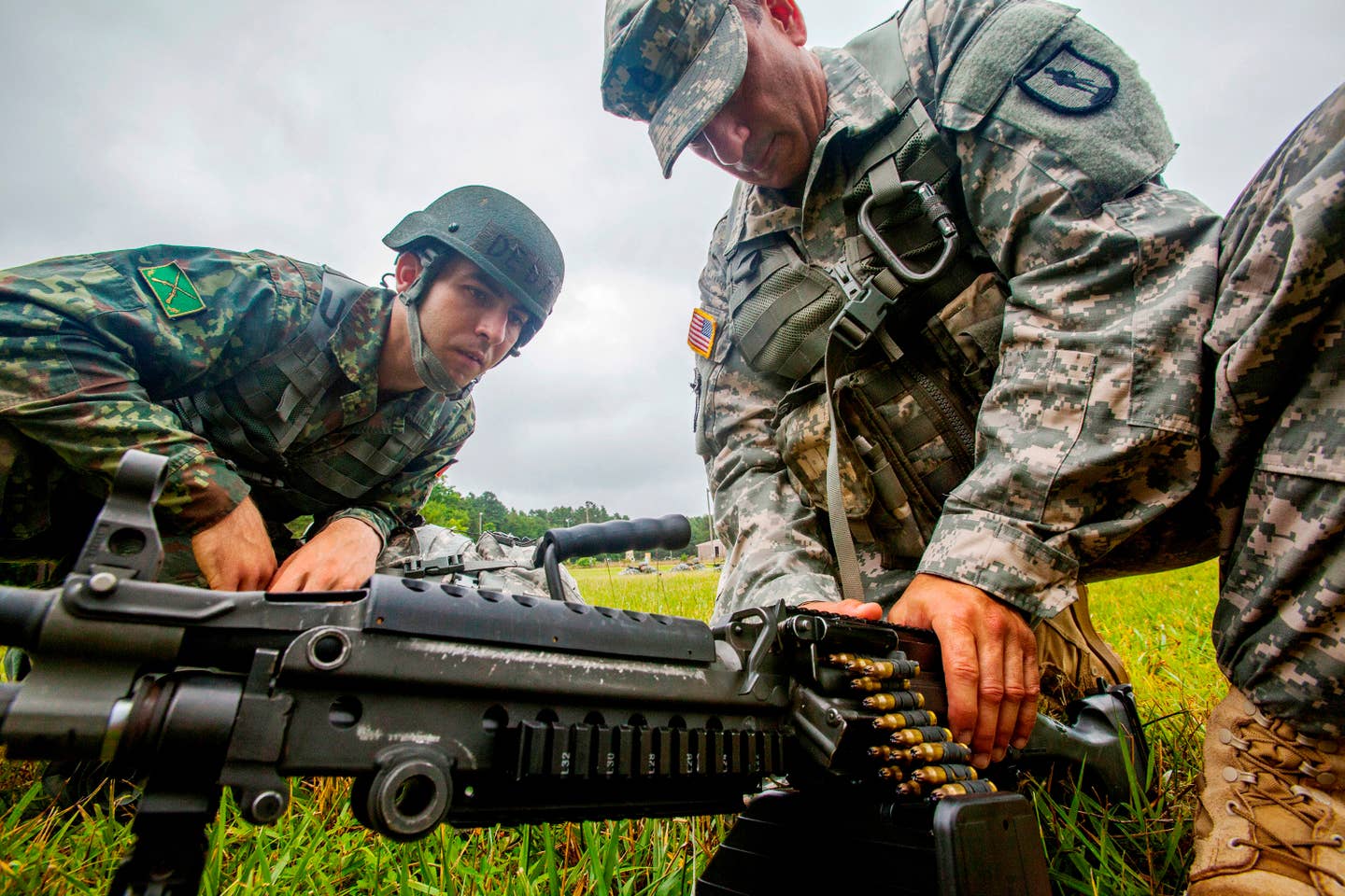 Sgt. 1st Class Harry R. Martinez, right, with the New Jersey Army National Guard, demonstrates how to load an ammunition drum on a M249 squad automatic weapon to Albanian Officer Candidate Endri Deda while training at Joint Base McGuire-Dix-Lakehurst, N.J.