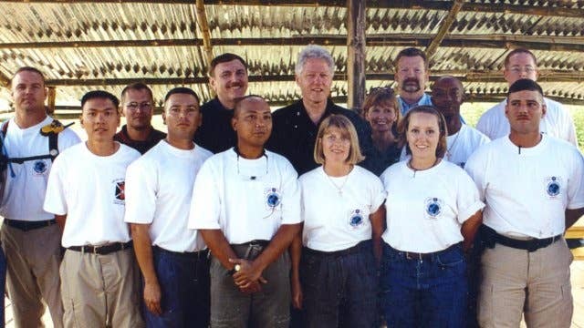 Johnie Webb stands next to then-President Bill Clinton during his visit to an excavation site.