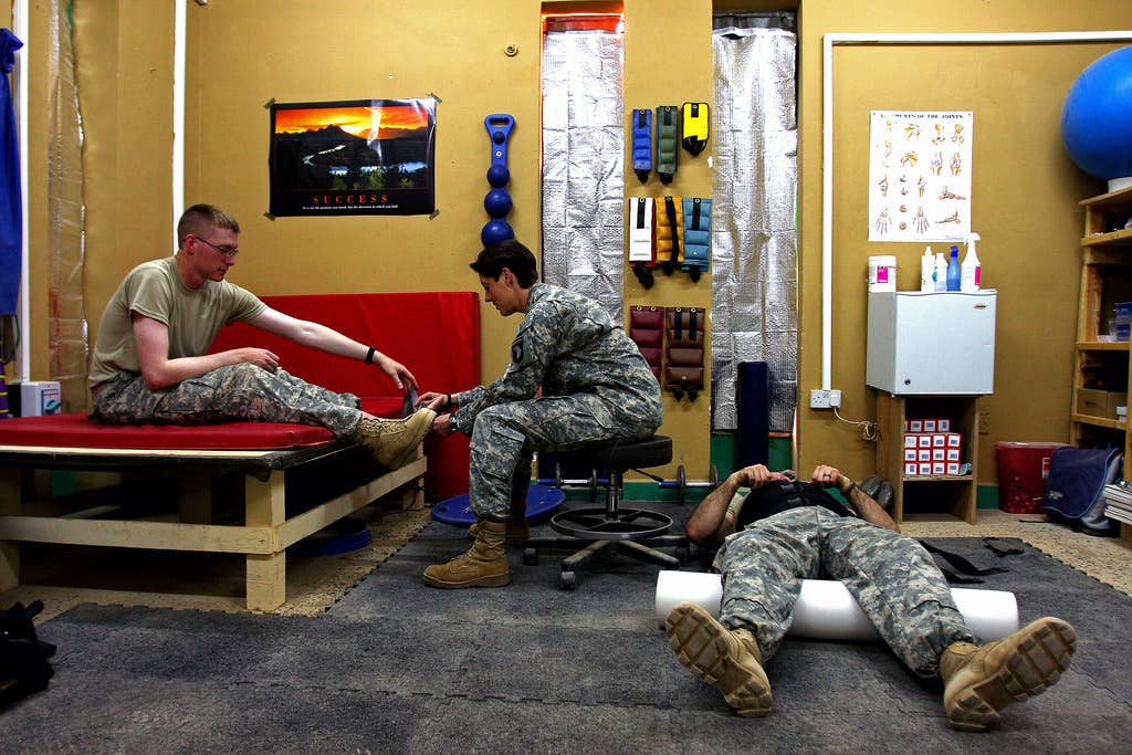 Staff Sgt. Rebecca Gaither, physical therapy NCOIC, 1st Brigade Combat Team, 101st Airborne Division (AA), helps Soldiers get back on their feet at Combat Operations Base Speicher, Iraq.