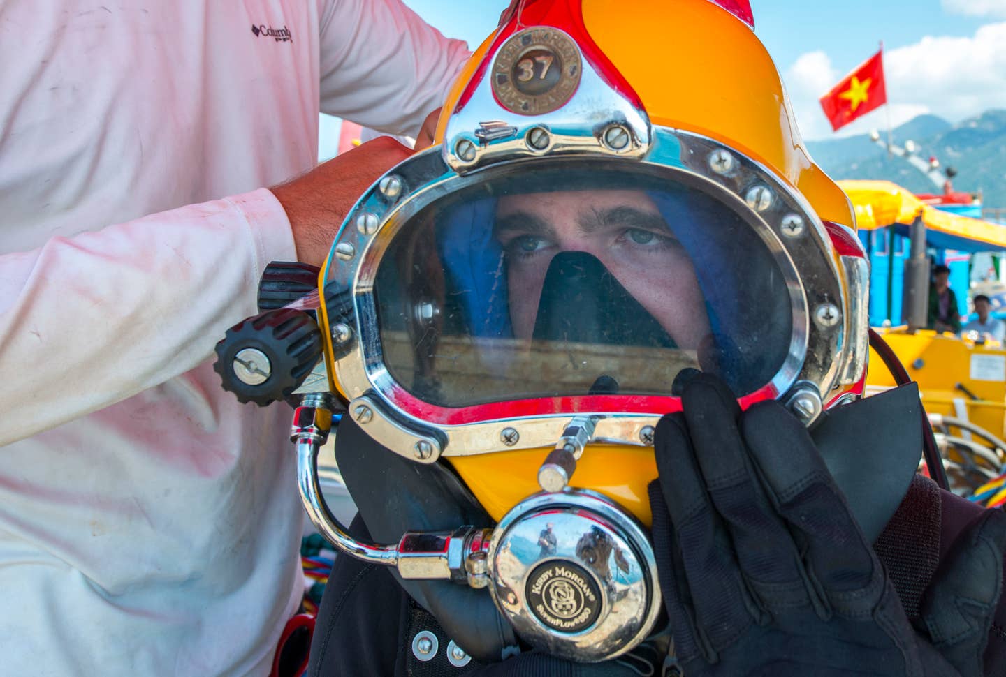Spc. Douglas Adams, a diver with the 7th Engineer Dive Detachment, puts on his diving helmet before he heads 80 feet below the surface as part of an underwater recovery mission near Nha Trang, Vietnam, March 19, 2018.