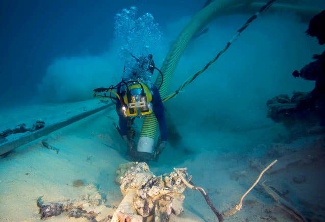 A Navy diver dredges with a venturi vacuum system during an underwater recovery mission in search of missing American service members from World War II near Palau, Jan. 24, 2018.