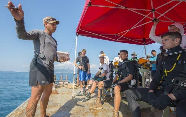 Staff Sgt. John Huff, a diving supervisor with the 7th Engineer Dive Detachment, briefs fellow divers before they dive 80 feet to the sea floor to collect sediment in search of the remains of American Soldiers near Nha Trang, Vietnam, March 19, 2018.