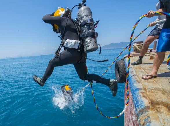 A pair of Army divers from the 7th Engineer Dive Detachment jump into the water during an underwater recovery mission near Nha Trang, Vietnam, March 20, 2018.