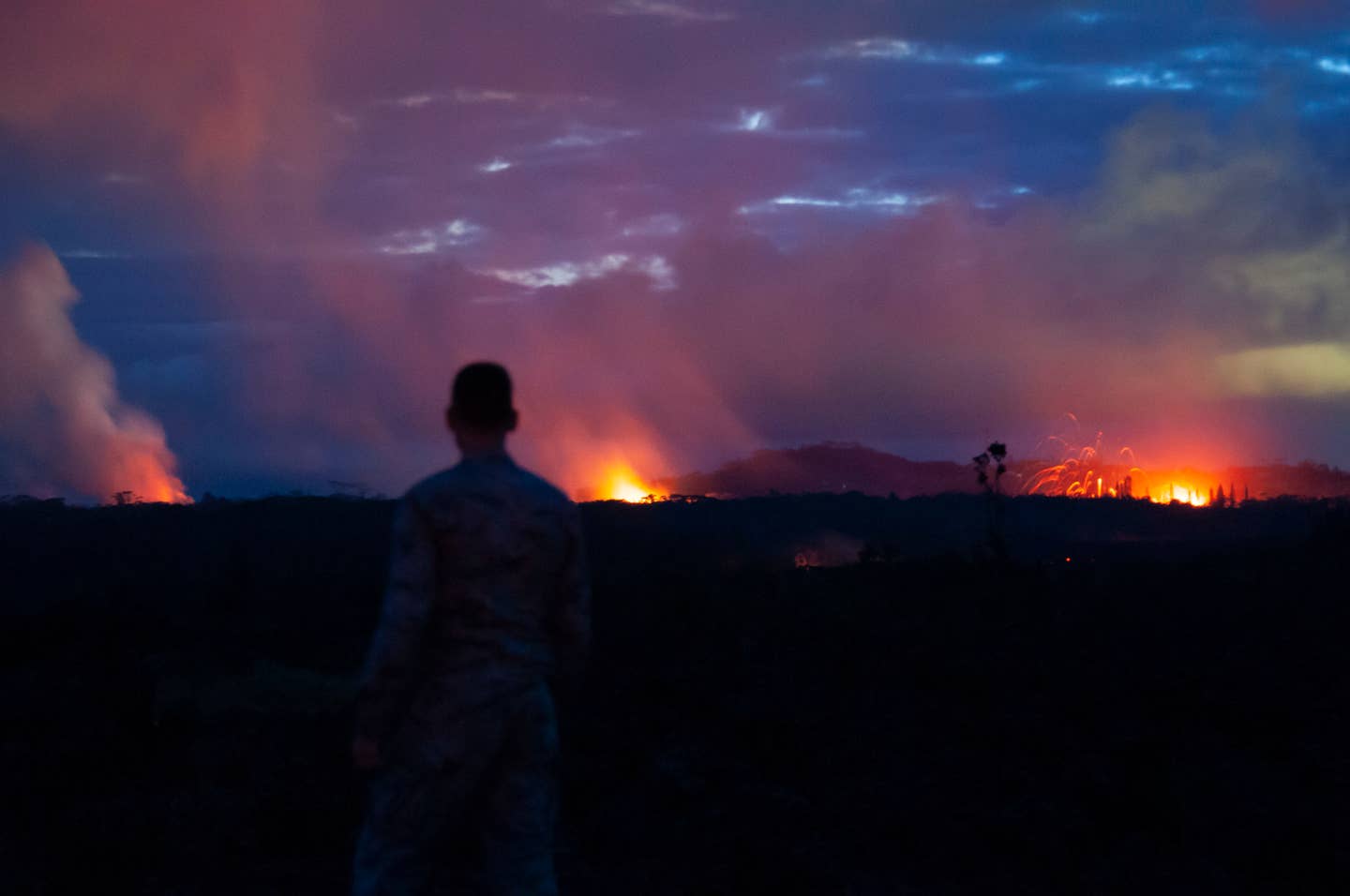 A member of the Hawaii National Guard observes three lava fissures May 15, 2018, at Leilani Estates and Lanipuna Gardens subdivisions, Pahoa, Hawaii.