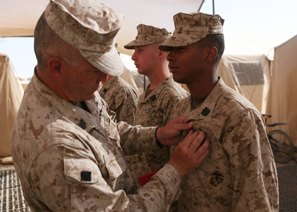 Hospital Corpsman Billy Knight get pinned with his FMF Warfare Specialist pin by Chief Petty Officer Garry Tossing during a ceremony at Camp Leatherneck, Afghanistan.
