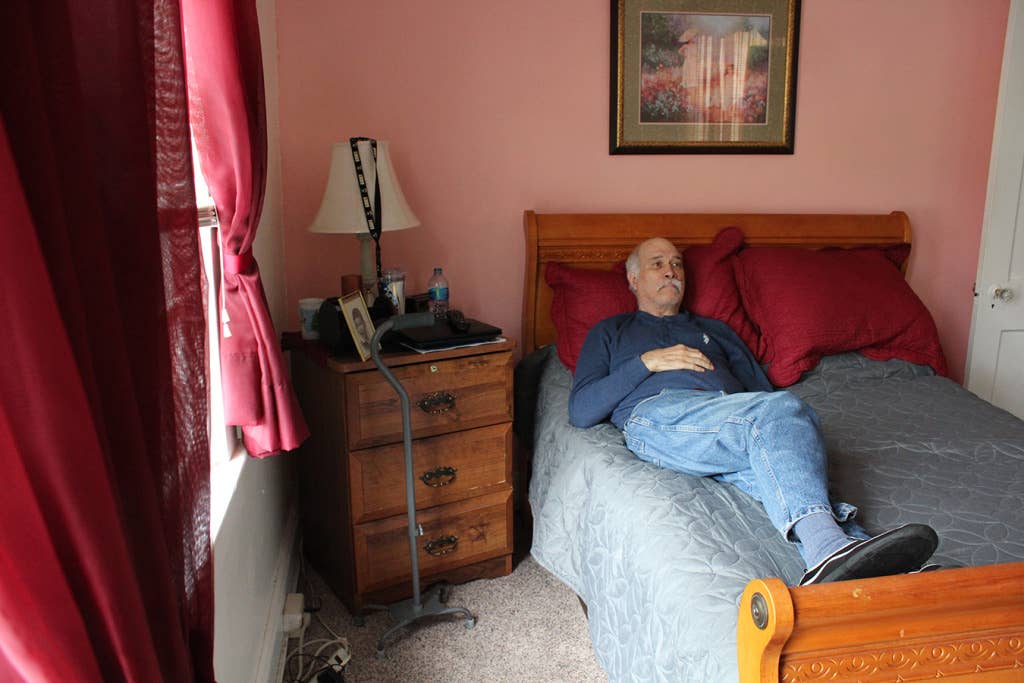 Frank Hundt watches TV in his bedroom at caregiver Joann West's home in Baltimore on May 18, 2018.
