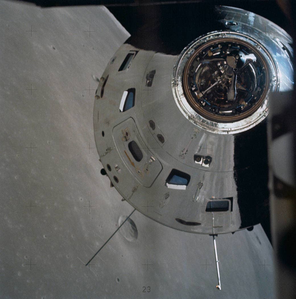 The surface of the moon is reflected in the command and service module.