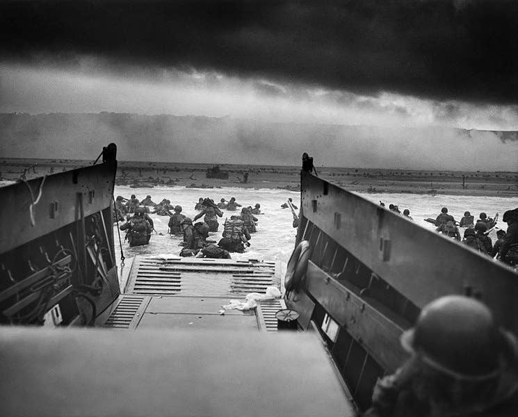 A LCVP (Landing Craft, Vehicle, Personnel) from the U.S. Coast Guard-manned USS Samuel Chase disembarks troops of Company E, 16th Infantry, 1st Infantry Division wading onto the Fox Green section of Omaha Beach on the morning of June 6, 1944.