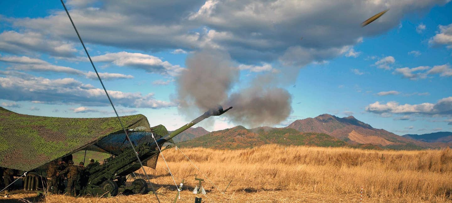 Marines fire an M777A2 155 mm howitzer