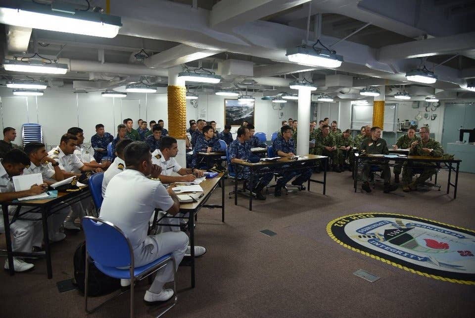 US, Japanese, and Indian personnel aboard Japan's Hyuga-class helicopter carrier JS Ise during Malabar 2018, June 7, 2018.