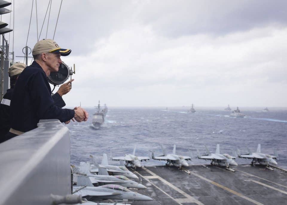 US Navy Rear Adm. Bill Byrne, commander of Carrier Strike Group 11, watches the end of Exercise Malabar 2017 from the aircraft carrier USS Nimitz, in the Bay of Bengal, July 17, 2017.