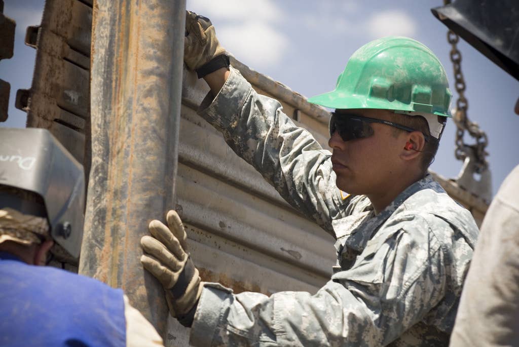 U.S Army Soldiers install steel runway planking for fence along the U.S./Mexico border in Naco, Ariz., June 28, 2007,