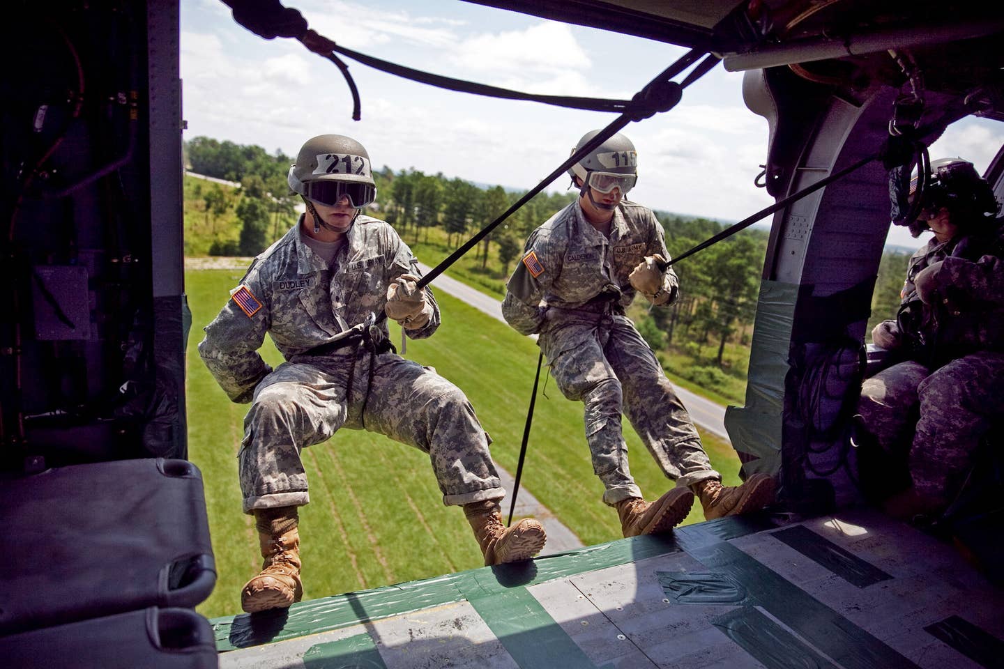 Reserve Officers' Training Corps (ROTC) Cadets Timothy Dudley and Nicholas Calderon move into position to rappel out of a UH-60 Black Hawk Helicopter during the last phase of the Air Assault Course at Dickman Field, July 23, 2013 at Fort Benning, Georgia.