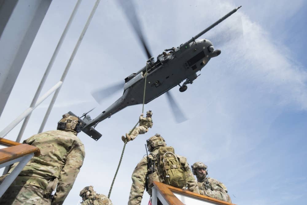 Members of a Maritime Safety and Security Team during fast-rope training from an Air National Guard helicopter.