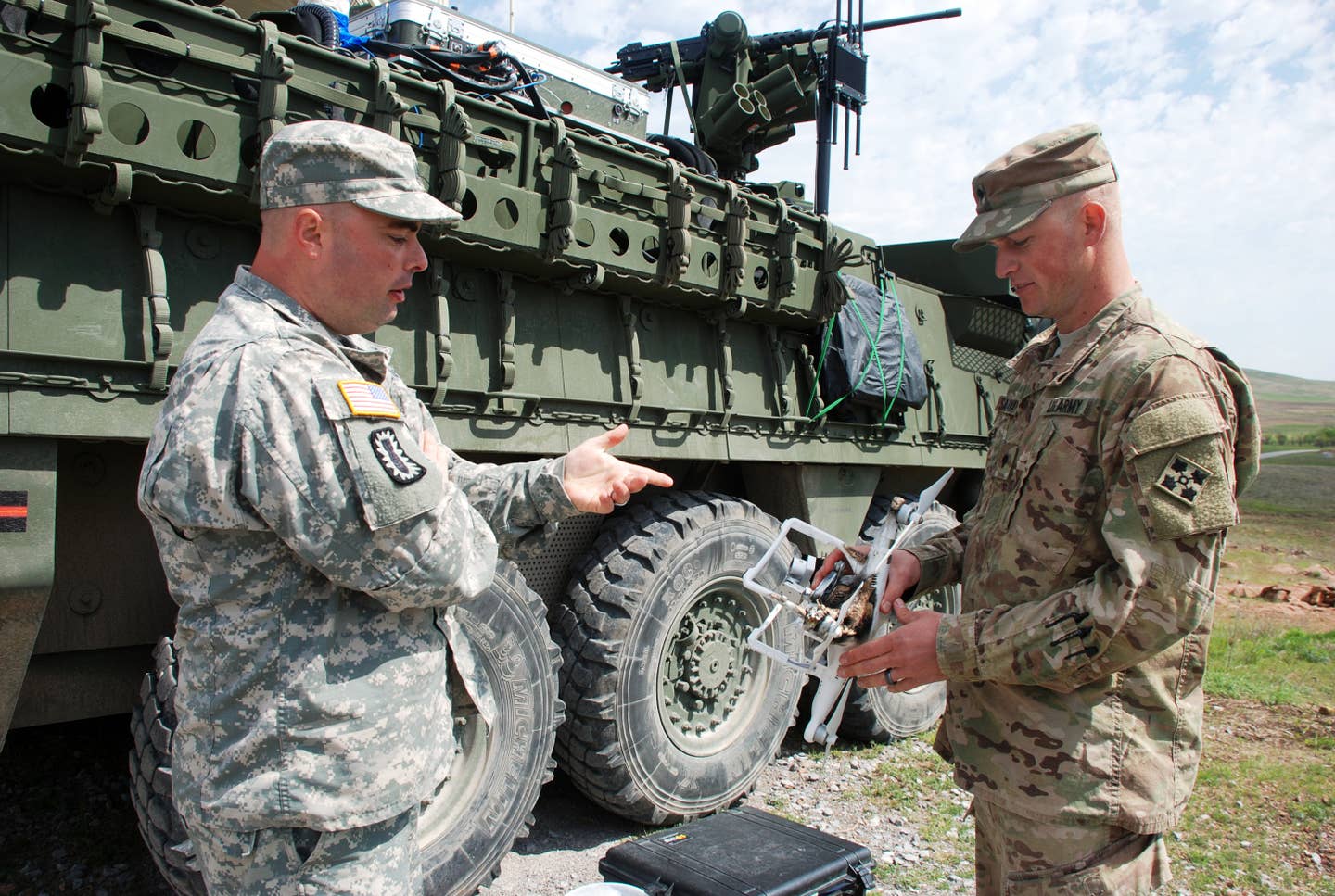 Spc. Brandon Sallaway, shows Staff Sgt. Eric Davisu00a0an unmanned aerial device he shot down with a laser during the Maneuver Fires Integrated Experiment.u00a0The lasers, Mobile Expeditionary High Energy Laser, were mounted on Stryker armored vehicles.