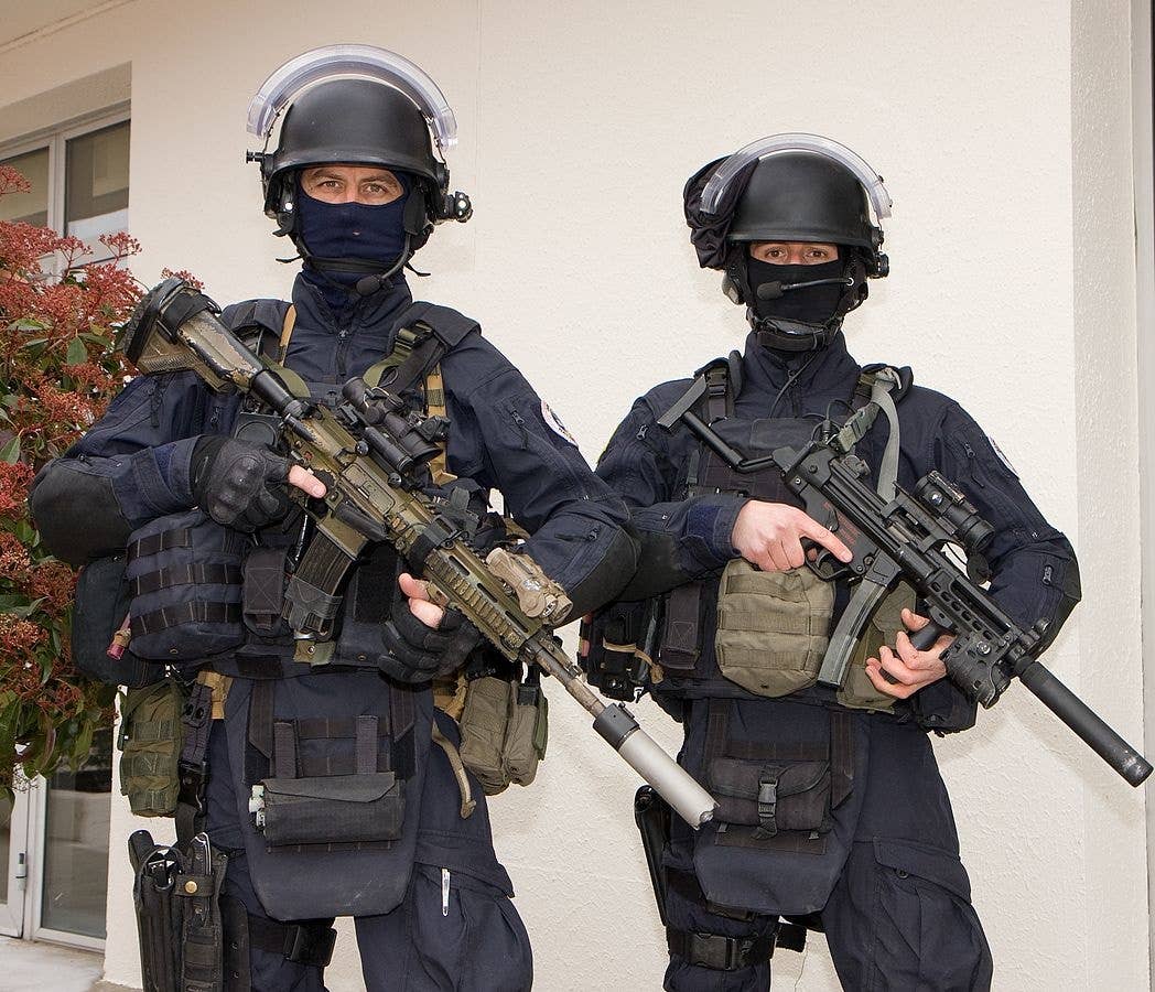 GIGN spec ops unit stand with their weapons ready and at alert
