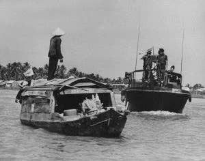 A Patrol Boat River and a sampan in Vietnam.<br>(U.S. Navy)