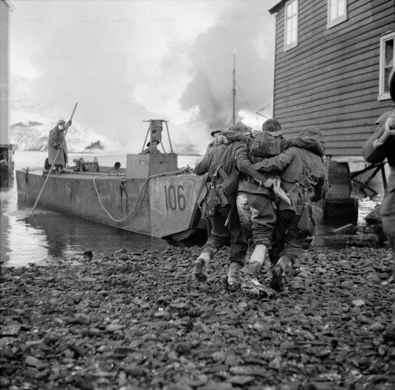Commandos carry the wounded to landing ships.<br>(Imperial War Museum)