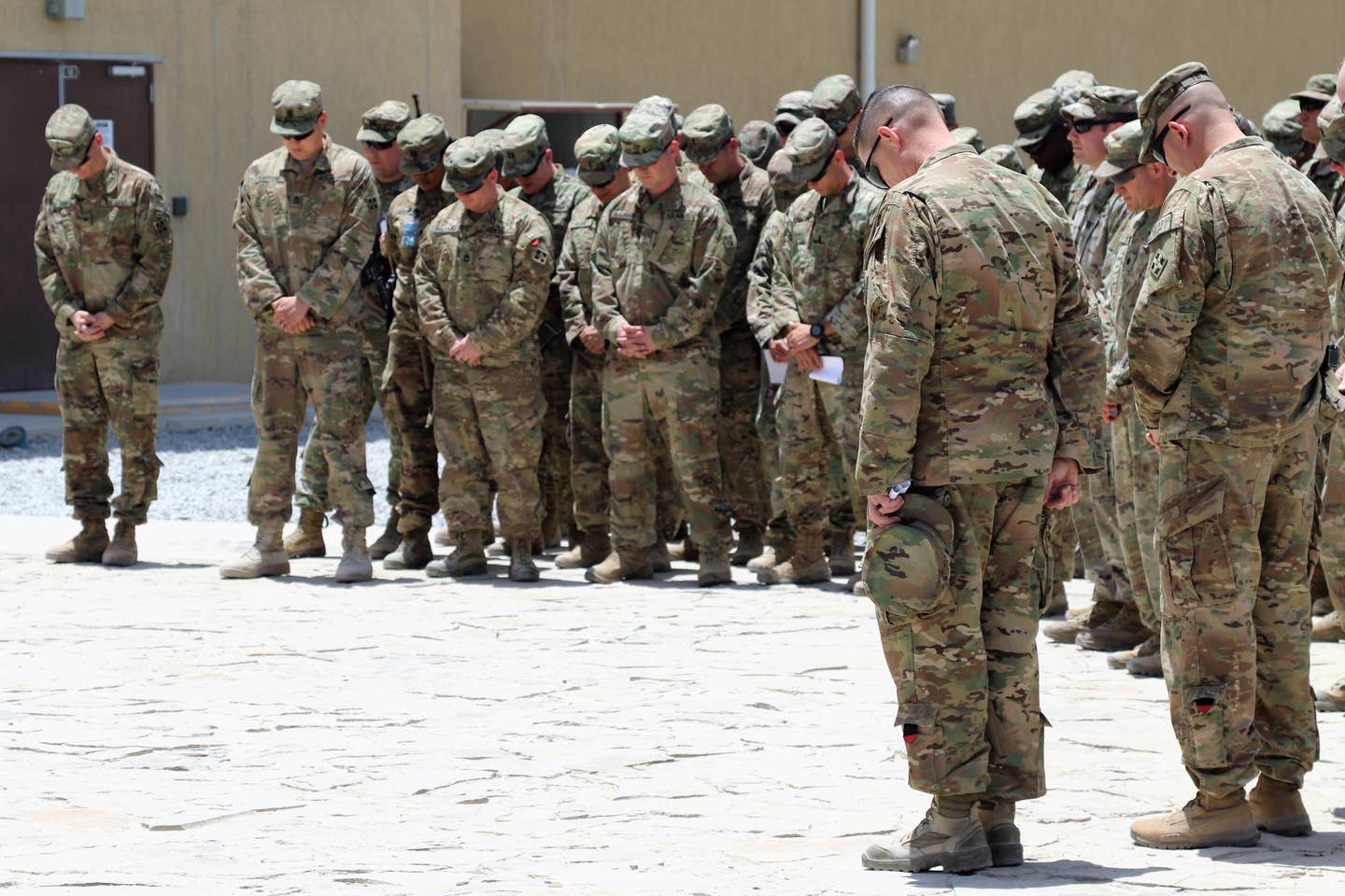 Soldiers bow their head in prayer during a Memorial Day Ceremony while deployed to Afghanistan.<br>(U.S. Army photo by Maj. Richard Barker)