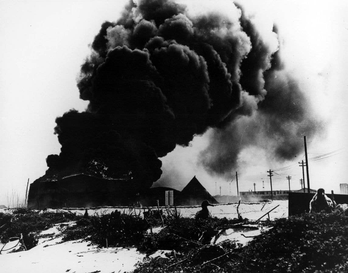 Oil tanks burn on Midway Atoll after a Japanese air attack at the outset of the Battle of Midway on June 4, 1942. (U.S. Navy)