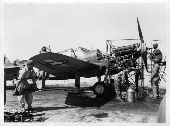 Black mechanics work on a P-40 Warhawk assigned to a "Tuskegee Airmen" unit in World War II.<br>(U.S. Air Force)