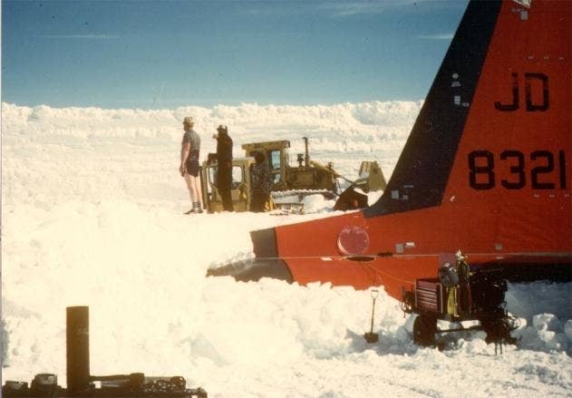 You will never be as cool as this guy wearing shorts to dig a plane out of the snow in Antarctica. If you're this hero, email me. (Update: This is equipment operator Dan Check. It turns out "The heater in the D-6 worked quite well, and when the sun was out and there wasn't much wind, the digging site was quite warm.")<br>(Photo by Jim Mathews)