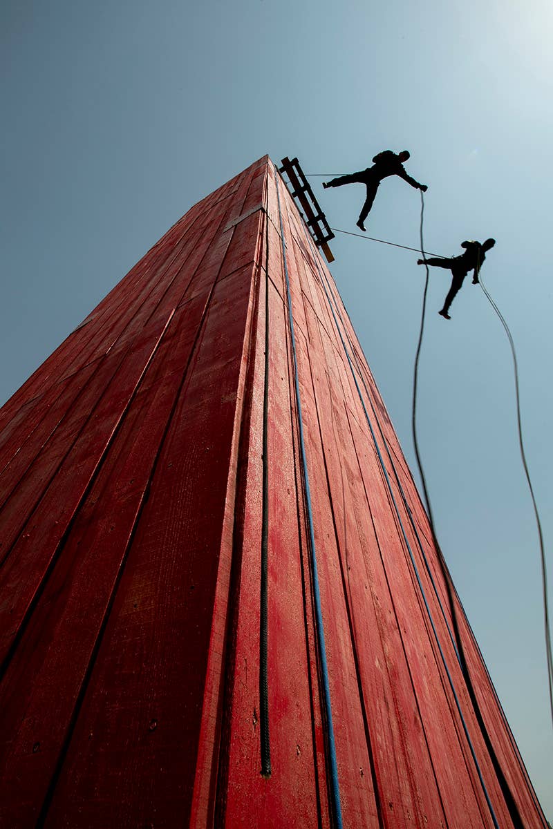 Iraqi Counter Terrorism Service (CTS) operators demonstrate forward repelling during the 2nd School graduation in Baghdad, Iraq, Oct. 1, 2018. The ceremony included a ribbon cutting for the repelling tower, which will be used by future 2nd school classes. (U.S. Navy Petty Officer 1st Class Abe McNatt)