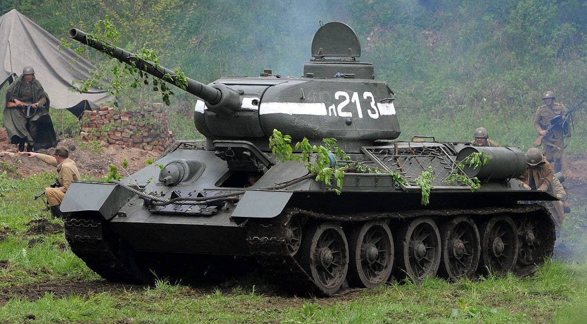 A T-34 tank sits with open hatches during a battle re-enactment. It was the most produced tank of World War II and could kill any tank in the world at the time of its debut. Meanwhile, Germans had to press anti-aircraft guns into service to try and kill it.<br>(Cezary Piwowarski, CC BY-SA 4.0)