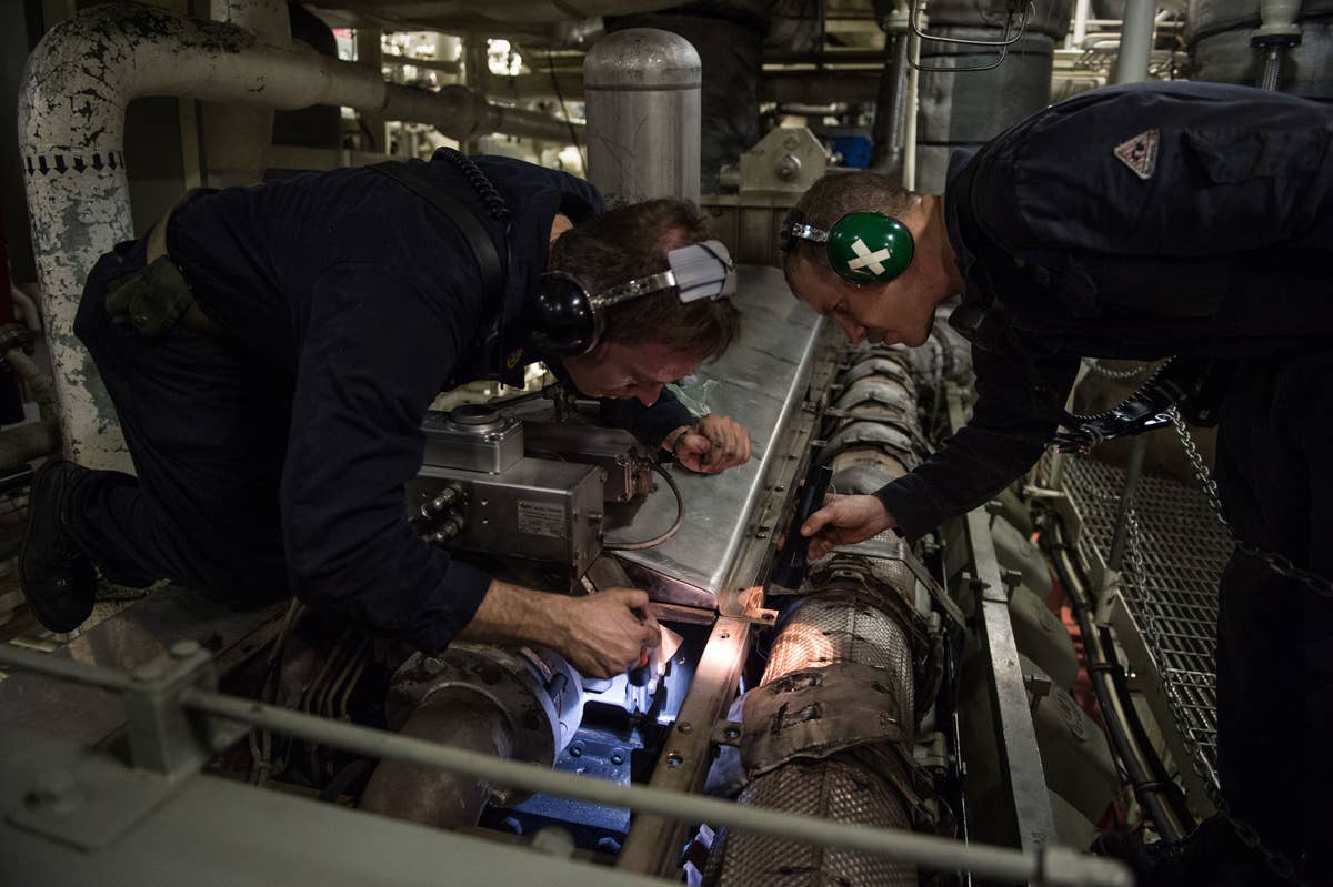 Chief Machinist Mate Benjamin Carnes and Gas Turbine Systems Technician 1st Class Johnathan Hovinga make final inspections in preparation to start the main engines on the littoral combat ship USS Fort Worth.<br>(U.S. Navy Mass Communication Specialist 2nd Class Antonio P. Turretto Ramos)