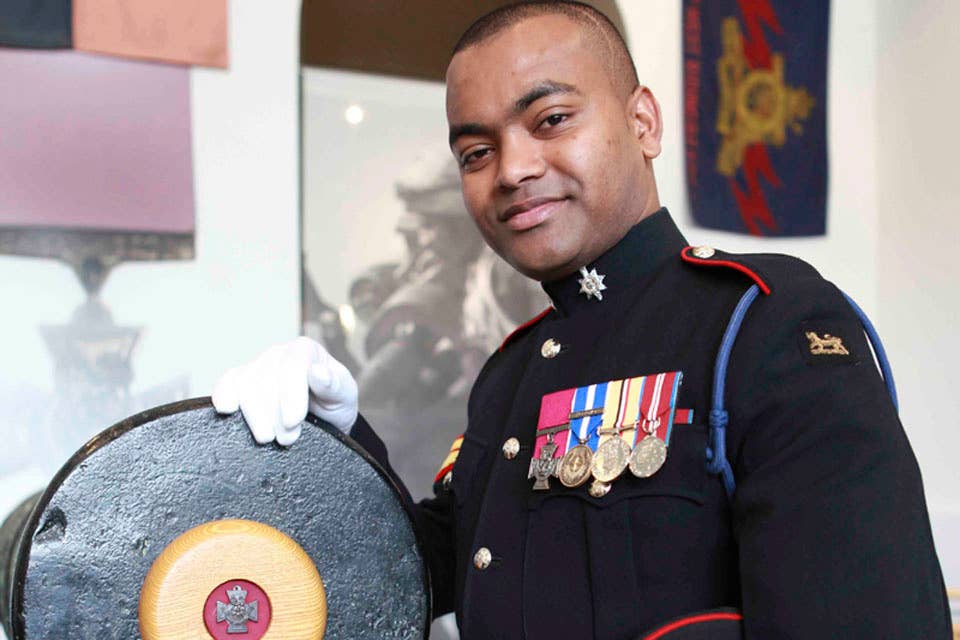 Corporal Johnson Beharry, VC, with one of the guns from which the Victoria Cross military award is struck.