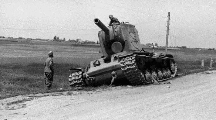 An abandoned Soviet KV-2 tank left by the roadside is inspected by curious German soldiers. (Bundesarchiv, CC BY-SA 3.0)