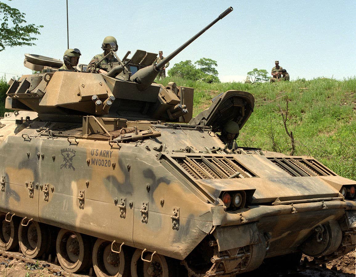 Crewmen in the coupla of an M-2 Bradley infantry fighting vehicle elevate the barrel during a 1987 exercise. (U.S. Army Pfc. Prince Hearns)