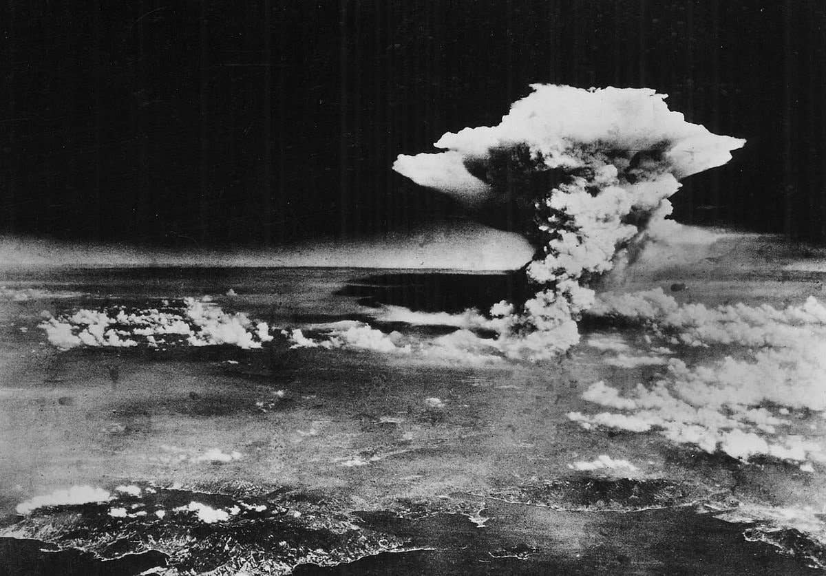 An atomic cloud rises over Hiroshima after the Little Boy bomb was dropped.<br>(509th Operations Group)