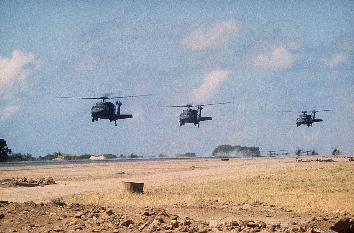 Three U.S. Army Sikorsky UH-60A Black Hawk helicopters prepare to touch down next to the Point Salines airport runway during "Operation Urgent Fury" on Oct. 25, 1983. (U.S. Army Spc. Douglas Ide)