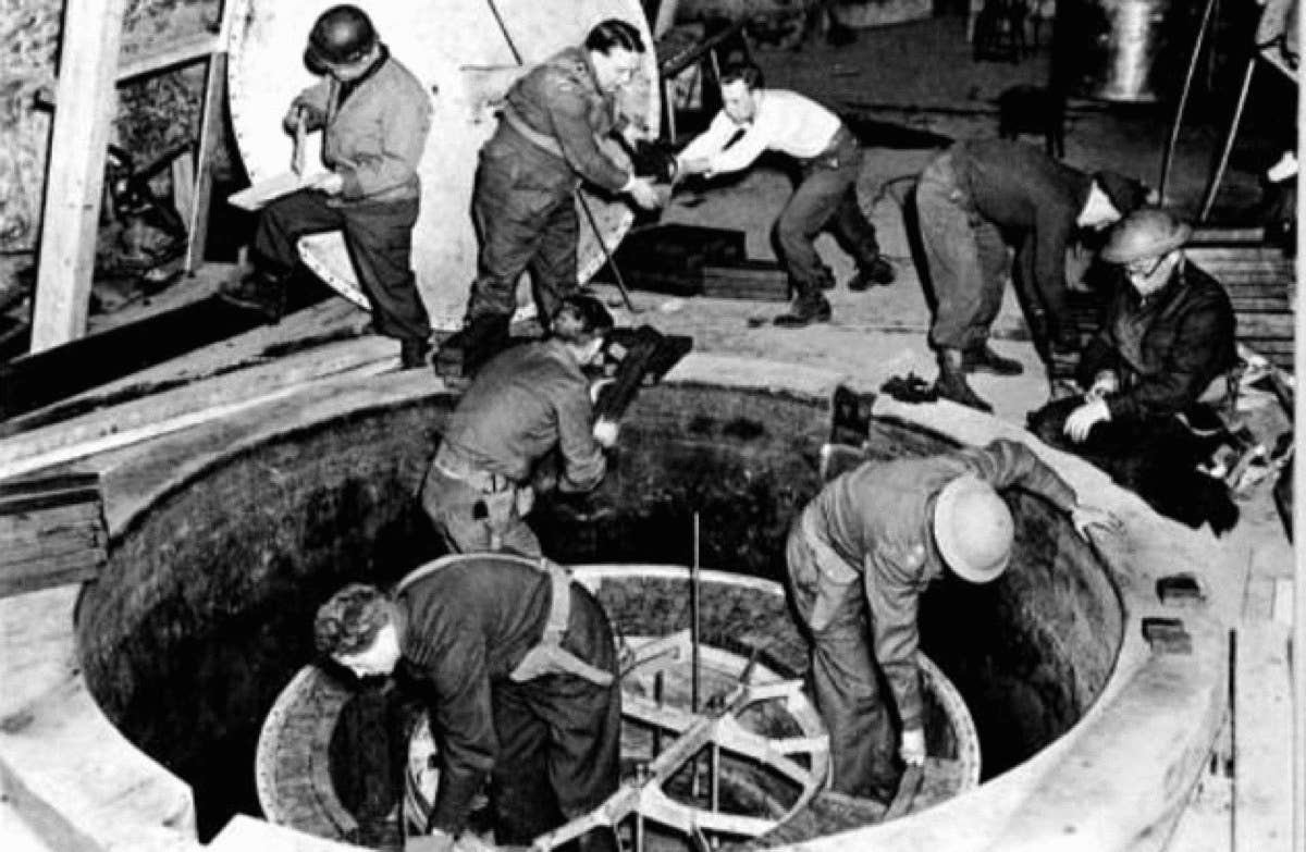 American soldiers dismantle a German nuclear reactor after World War II. The reactor never achieved a sustained reaction because the Germans never put enough of their uranium cubes in one spot.<br>(Public domain)