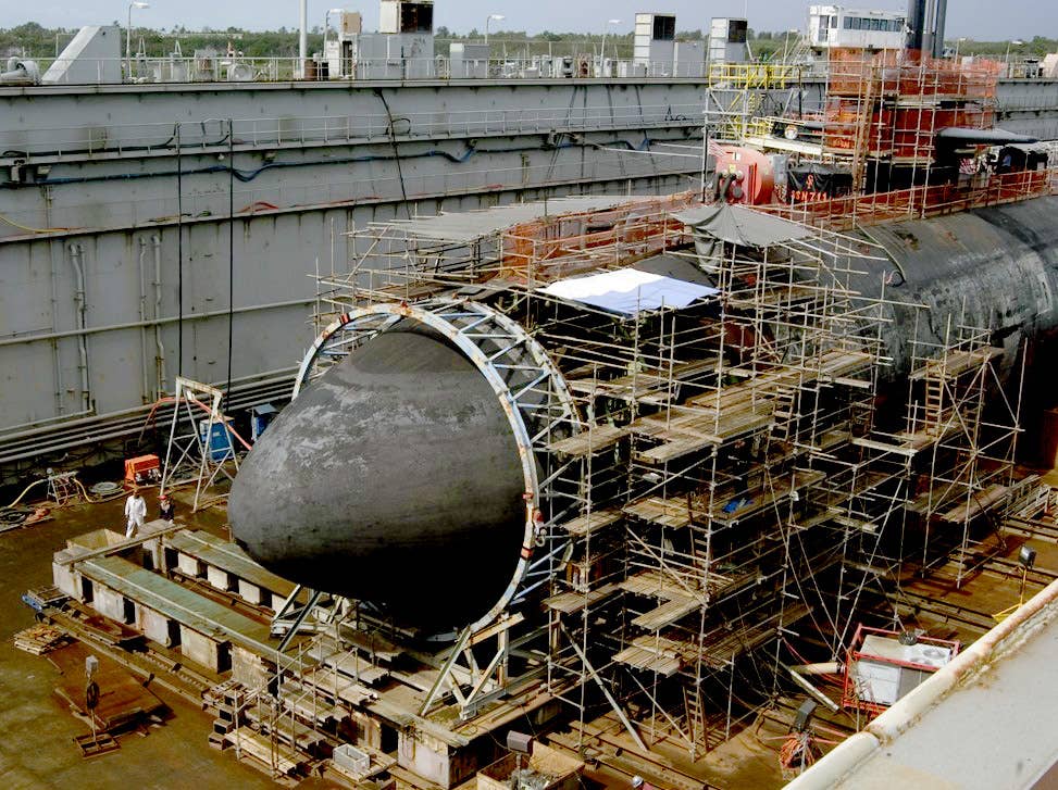 The Los Angeles-class submarine USS San Francisco shown in dry dock is having repairs made on its damaged bow. A new large steel dome about 20 feet high and 20 feet in diameter was put in the place of the damaged bow. (U.S. Navy)