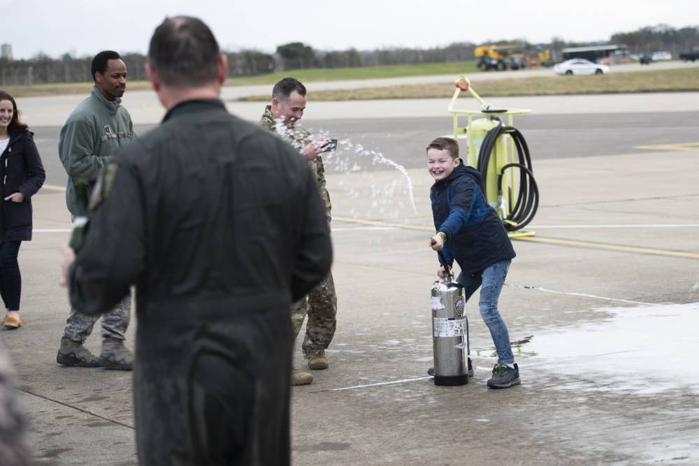 Noah Strasbaugh, son of U.S. Air Force Maj. Steven Strasbaugh, 351st Air Refueling Squadron assistant director of operations, sprays his dad with water in celebration of his "fini-flight" at RAF Mildenhall, England, Feb. 28, 2019. Dating back to World War II, the U.S. military has celebrated pilots' and other experienced officers' final flights either at their current unit or their career. U.S. Air Force/Emerson Nuñez
