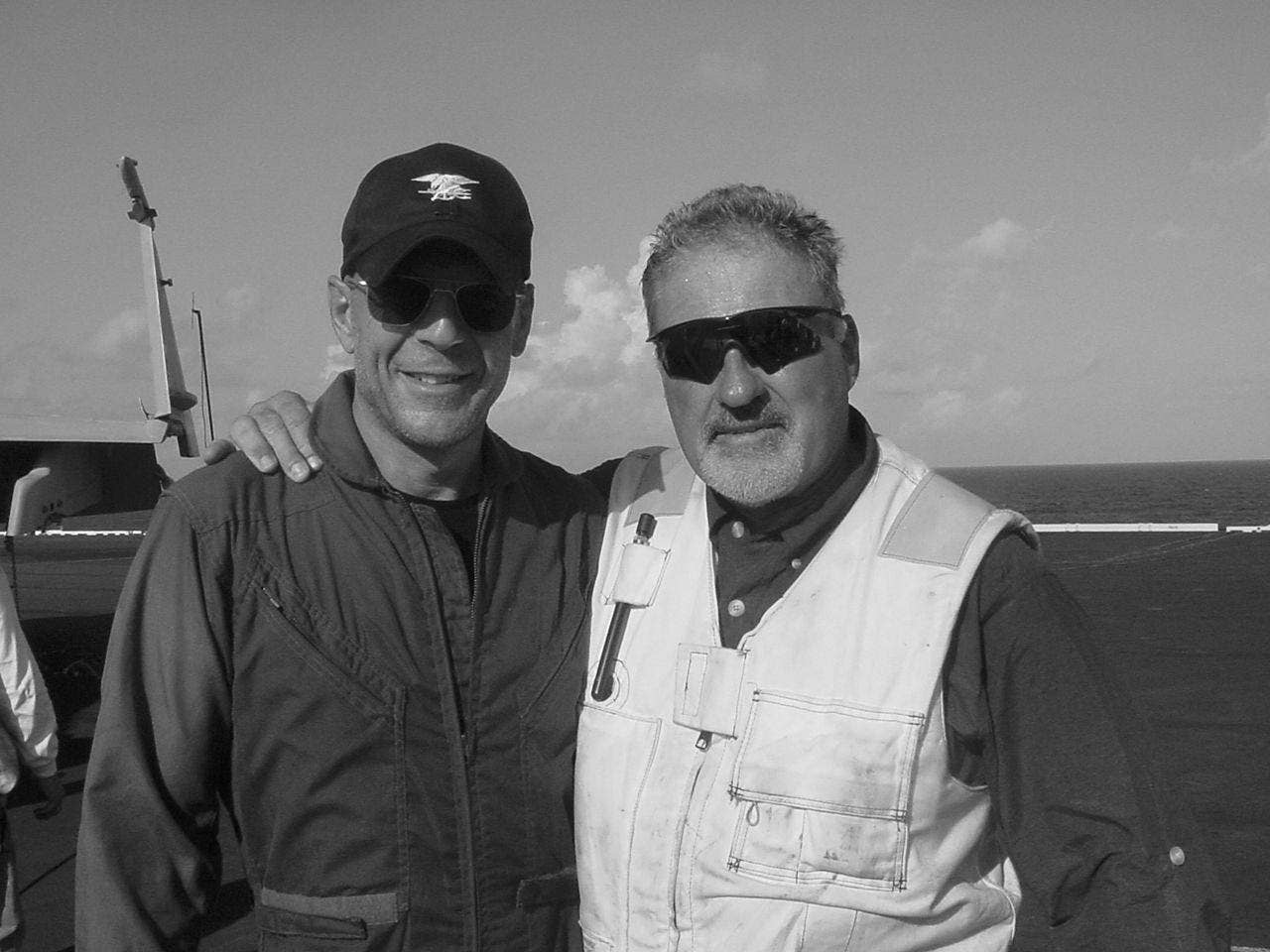 Bruce Willis and Harry Humphries on (HS TRUMAN CVN 75) set for <em>Tears of the Sun</em>. Photo credit Wikipedia.