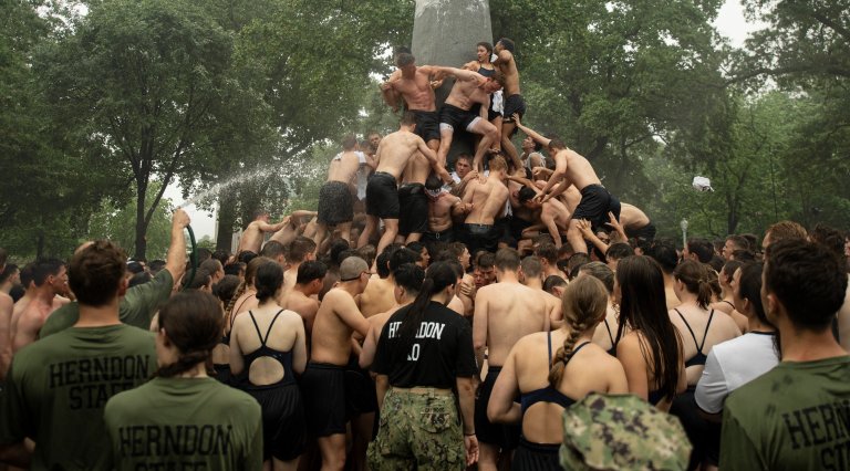 U.S. Naval Academy plebes climb the Herndon Monument to commemorate their freshman year. weird military traditions The Herndon Monument Climb usna