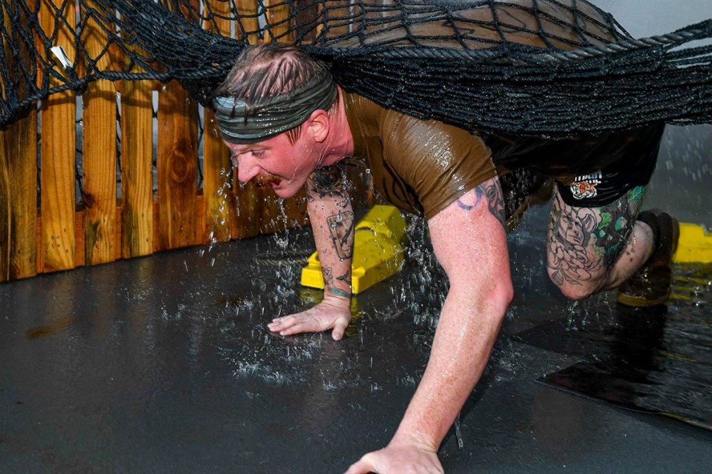 Gunners Mate 2nd Class Treat Peterson maneuvers through an obstacle course during a crossing the line ceremony at global coordinates 00.00N/00.00W to earn Emerald Shellback status on board the Expeditionary Sea Base USS Hershel “Woody” Williams