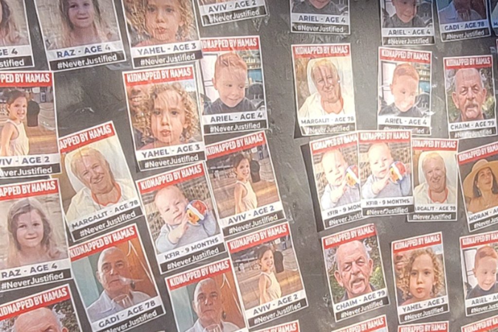 Photos of hostages taken by Hamas on Oct.7, 2023, with names and ages and the hashtag #NeverJustified.