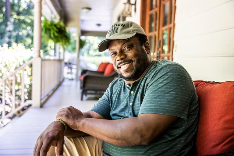 Portrait of U.S. military veteran on front porch of suburban home