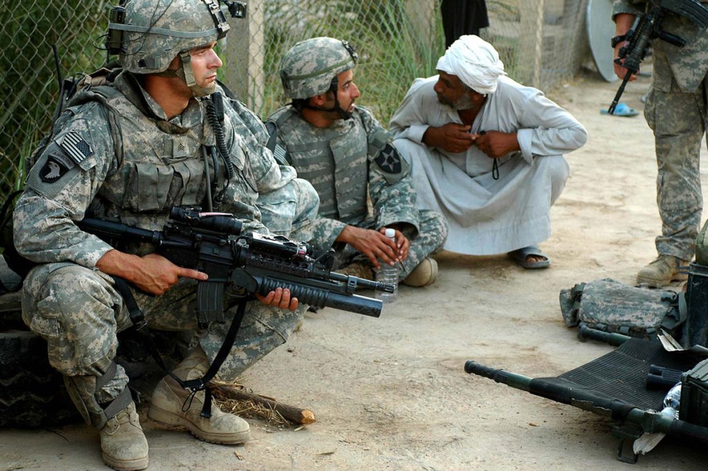 Sgt. Nick Arocho, a team leader with 1st Platoon, Company B, 4-9 Infantry Regiment, pulls security as an Iraqi man speaks to an interpreter, June 19, in a village in the outskirts of Baqubah. Soldiers of 4th Battalion, 9th Infantry Regiment, 4th Stryker Brigade Combat Team are assisting Soldiers of 3rd Stryker Brigade Combat Team in the clearing of Baqubah, a major operation known as "Arrowhead Ripper," by isolating Baqubah just outside the city limits, to prevent insurgents from getting in, or out, of the city. Both Stryker brigades are with the 2nd Infantry Division, from Fort Lewis, Wash.