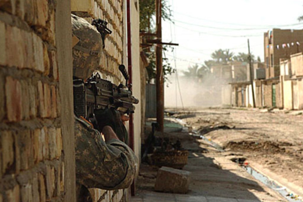 A soldier assigned to the 1st Platoon, Company B, 1-12 Combined Arms Battalion, 3rd Brigade Combat Team, 1st Cavalry Division, guards a street in the neighborhood of Tahrir in Baqubah, Iraq, March 28, 2007.
