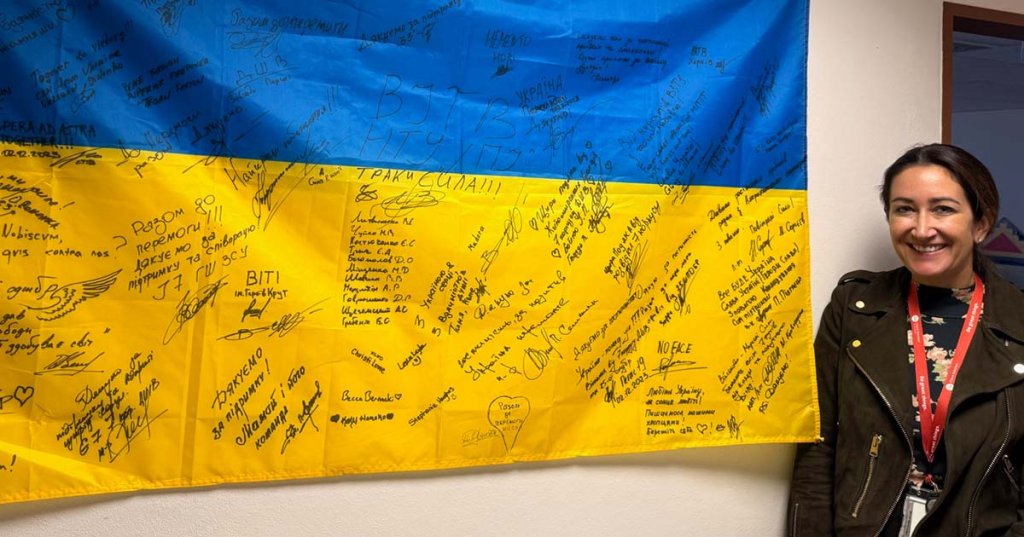 ellen barletto with a flag signed by soldiers