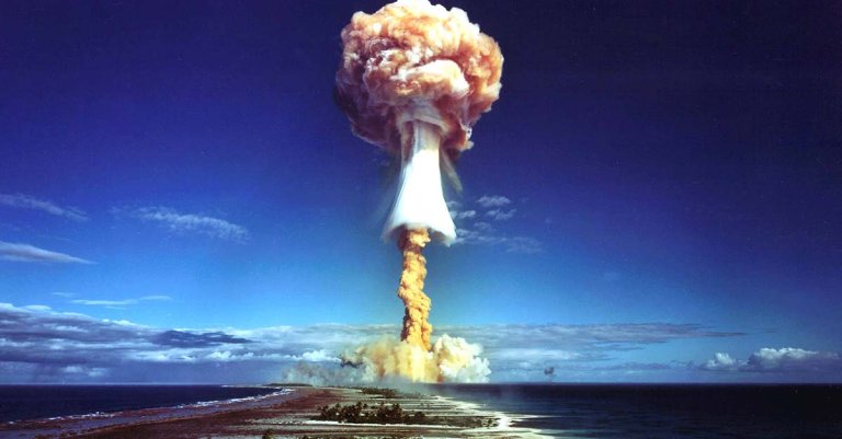A tall mushroom cloud rises over the Pacific at Bikini Atoll after World War II.