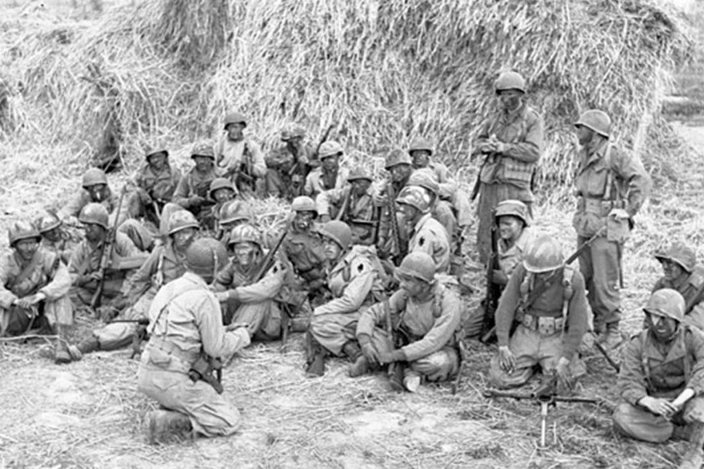 black seminole first special service force canada being briefed before setting out on a patrol, Anzio beachhead, Italy. (Lt. C.E. Nye/Library and Archives Canada)