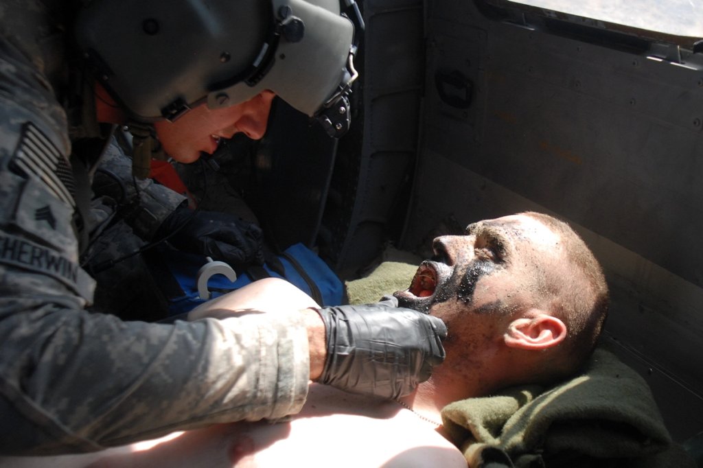 U.S. Army Pfc. Shawn Williams is treated by flight medic U.S. Army Sgt. Daniel Sherwin en route to the Kandahar Airfield Medical Unit for additional treatment after he was injured by a roadside bomb on June 17, 2011, in the Kandahar province of Afghanistan.